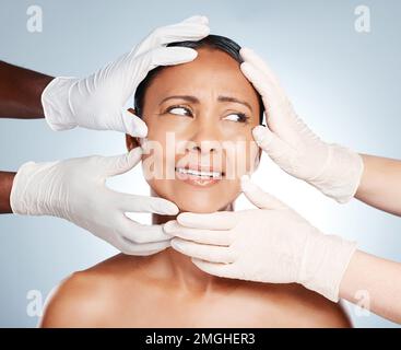 Chirurgie plastique, peur et visage de la femme avec les mains de médecins isolés sur fond bleu. Soins de la peau, chèque et personne âgée inquiet au sujet du botox Banque D'Images
