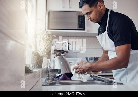 Nettoyage de la cuisine, lavage de la vaisselle et un homme dans la maison, la maison ou l'appartement pour nettoyer pour la sécurité des bactéries. Homme nettoyant personne à l'évier avec un chiffon dedans Banque D'Images