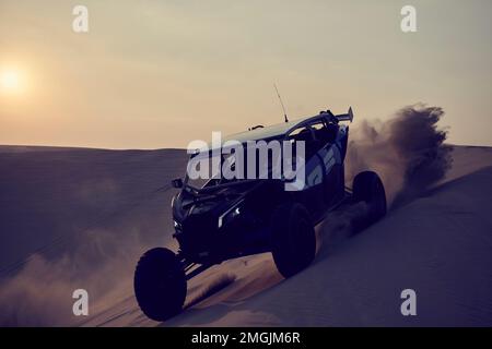 Un 4x4 en buggy au-dessus des dunes près de Doha, où les touristes et les amateurs de sensations fortes de Qataris se rendent pour se divertir. Banque D'Images