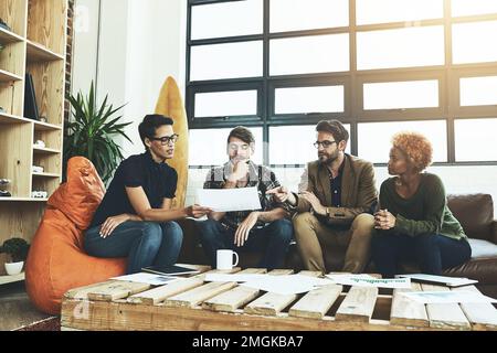 Toutes les idées sont importantes. un groupe de jeunes concepteurs discutant de la paperasse. Banque D'Images