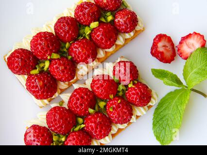 deux tartes aux fraises fraîches à la crème, au pistache et au miel Banque D'Images