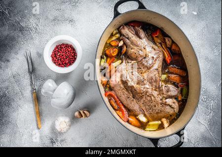 Épaule de mouton d'agneau braisée dans un plat de cuisson avec des légumes au vin rouge. Arrière-plan blanc. Vue de dessus Banque D'Images