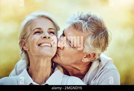 Couple senior, baiser et joue avec le sourire pour l'amour, le romantisme et s'embrasser ensemble dans la nature en plein air. Bonne femme âgée et homme embrassant le visage pour Banque D'Images