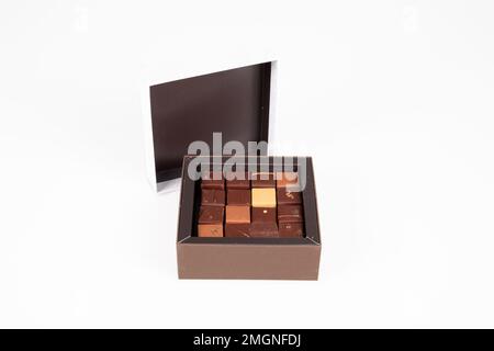 variété brune carré fine artisanale chocolat pralines sucreries dans boîte ouverte sur fond blanc Banque D'Images