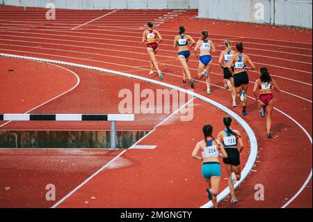 Les athlètes féminins repoussent leurs limites en course longue distance. Parfait pour les campagnes sportives et de remise en forme, mettant en valeur l'endurance et Banque D'Images