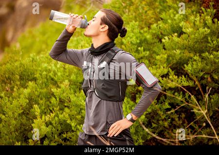 Homme, coureur fitness et eau potable à l'extérieur pour la randonnée, l'entraînement cardio ou l'exercice. Athlète, pause sportive avec boisson au biberon et sports Banque D'Images