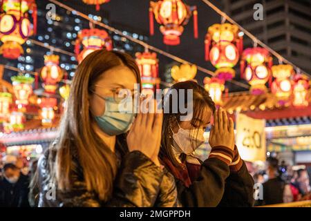 Deux dames prient pour une bonne fortune au Temple Wong Tai Sin à Hong Kong. Les gens se sont enfermés au Temple Wong Tai Sin pour adorer la première fois en trois ans depuis la pandémie de COVID, alors qu'ils se rassemblent pour brûler leurs premiers bâtons de jos pour célébrer le nouvel an lunaire et l'année du lapin dans le zodiaque chinois. Banque D'Images