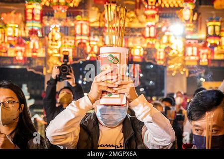 Hong Kong, Hong Kong. 21st janvier 2023. Un homme prie avec les objets de culte dans ses mains dans le Temple Wong Tai Sin à Hong Kong. Les gens se sont enfermés au Temple Wong Tai Sin pour adorer la première fois en trois ans depuis la pandémie de COVID, alors qu'ils se rassemblent pour brûler leurs premiers bâtons de jos pour célébrer le nouvel an lunaire et l'année du lapin dans le zodiaque chinois. (Photo par Alex Chan TSZ Yuk/SOPA Images/Sipa USA) crédit: SIPA USA/Alay Live News Banque D'Images