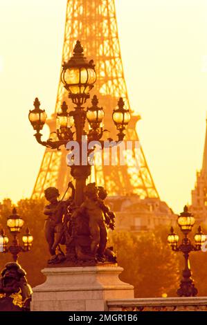 France, Paris, Ponte Alexandre, statuaire des chérubins et lampadaire avec la Tour Eiffel à l'arrière-plan. Banque D'Images