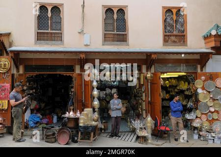 Fez, Maroc - trois vendeurs de sexe masculin se trouvent devant leurs boutiques sur la place Seffarine. Souq (marché) à Fès el Bali vend des produits en cuivre et en laiton. FES Banque D'Images