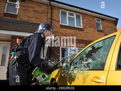 Les policiers de l'équipe opérationnelle se cassent dans une voiture suspecte à Gloucester où l'une des séries de raids à l'aube a été faite dans le cadre de l'opération Z Banque D'Images