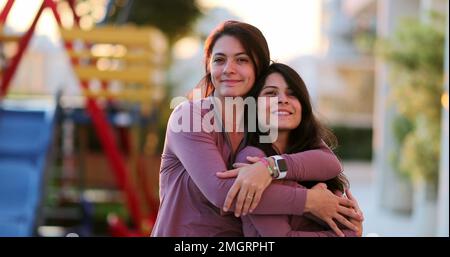 Deux sœurs adultes heureux posant ensemble à l'extérieur de frères et sœurs jumeaux avec les mêmes vêtements Banque D'Images