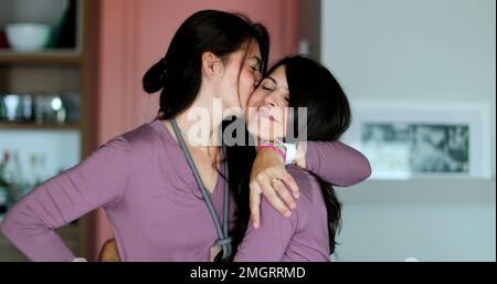 Les sœurs jumelles qui se posent ensemble deux femmes amis embrassent et aiment Banque D'Images