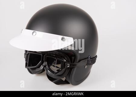 casque de moto noir avec visière et lunettes de protection antisoleil rétro et vintage style course de café Banque D'Images