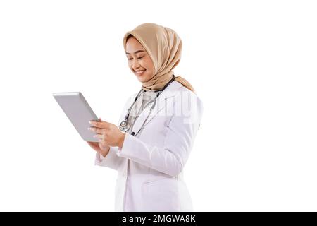 un beau médecin avec hijab regardant la tablette et souriant Banque D'Images