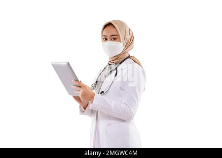 une femme médecin avec hijab apporter le comprimé à sa main Banque D'Images
