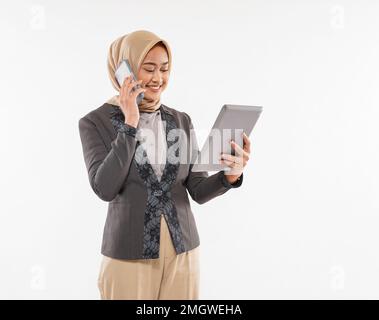 une belle femme avec hijab debout et appelant quelqu'un au téléphone Banque D'Images