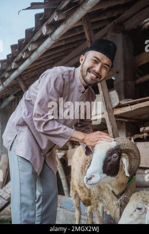 un musulman debout devant l'écurie de la chèvre Banque D'Images