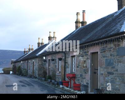 Une rangée de chalets en pierre dans Pier Road dans le village de conservation de Luss sur les rives occidentales du Loch Lomond, une destination touristique populaire. Banque D'Images