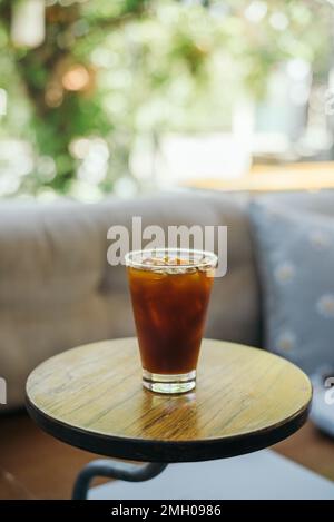 Café Americano glacé sur une table de café intérieure en bois Banque D'Images