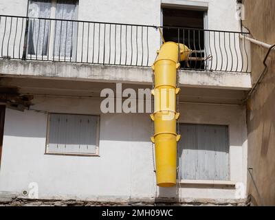 glissière en plastique pour l'élimination des débris sur le chantier de rénovation de la façade du bâtiment dans la rue de la ville par rapport au sol du site Banque D'Images