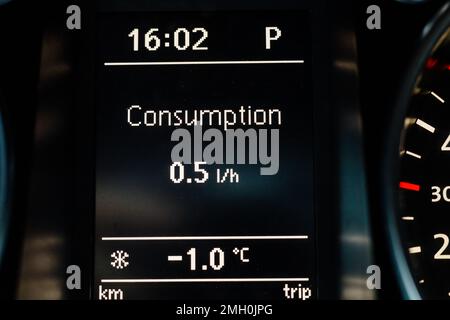 L'écran du tableau de bord de la voiture indique la consommation de carburant au ralenti et la température de l'air à l'extérieur Banque D'Images