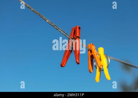 Épingles à linge colorées sur les cintres. Épingles à linge en plastique de différentes couleurs. Banque D'Images