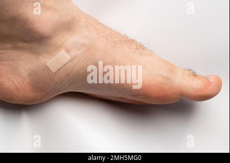 Bandage médical sur jambe humaine isolé sur fond blanc studio vue rapprochée Banque D'Images