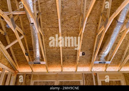 Lors de la construction d'un nouveau bâton construit à la maison, les tuyaux de ventilation sont installés dans le matériau d'isolation argent sur le plafond Banque D'Images