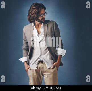 HES un homme avec une telle classe. Photo studio d'un beau jeune homme posant sur un fond gris. Banque D'Images