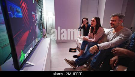 Vue arrière d'une personne jouant à des jeux vidéo à la maison Banque D'Images