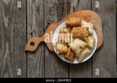 des crêpes enveloppées sur une assiette pour le petit déjeuner sont sur la table dans la cuisine, des crêpes pour le petit déjeuner Banque D'Images