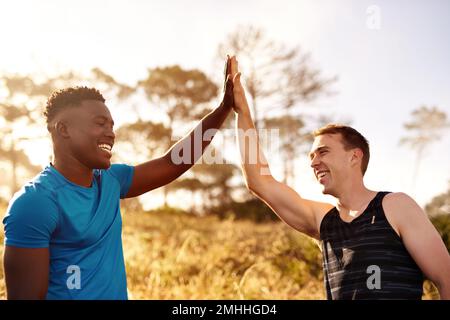 Quelle belle course qui a été. deux jeunes hommes sportifs qui se font un pied-à-tête à l'extérieur. Banque D'Images