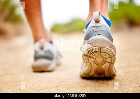 Fitness, chaussures et sports personne marchant, courant et l'entraînement d'homme sur le chemin. Gros plan arrière de la coureur, des pieds et des baskets sur le sol pour l'exercice, garez-vous Banque D'Images