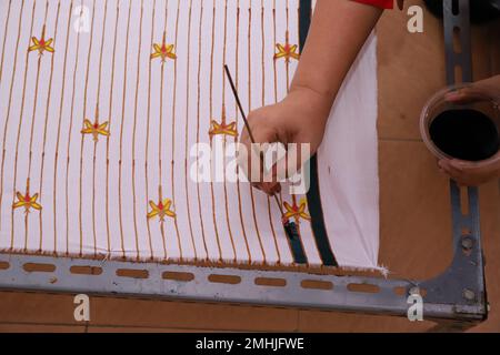 Une femme fait des croquis à la main avec des outils de cantage et de la cire chaude pour faire Batik traditionnel Banque D'Images