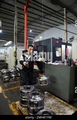 CHONGQING, CHINE - 27 JANVIER 2023 - des employés soulèvent des pièces dans un atelier de production à Chongqing, Chine, 27 janvier 2023. Banque D'Images