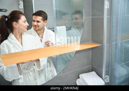 Jeune couple faisant leur routine matinale dans la salle de bains Banque D'Images