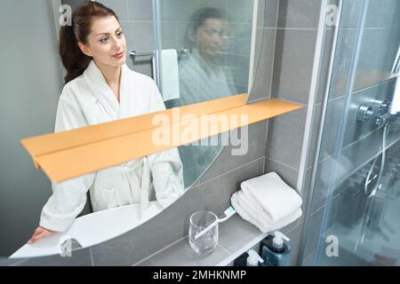 Belle jeune femme se tient devant un miroir Banque D'Images
