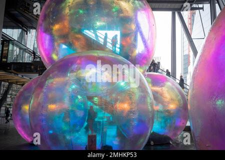 Les employés des bureaux de la ville font monter des escaliers mécaniques au-dessus d'une œuvre d'art intitulée « Evanescent », qui sera exposée en janvier et février au Leadenhall Building de la City de Londres, le quartier financier de la capitale, le 26th janvier 2023, à Londres, en Angleterre. Evanescent est un libre de visiter l'installation publique qui cnsistening d'un amas de bulles gigantesques qui ensemble tour à plus de sept mètres de hauteur. L'œuvre, de l'atelier Sisu, a été placée à côté de l'entrée ouest du Leadenhall Building, alias « le Cheesegrater ». Banque D'Images