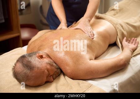 L'homme âgé subit un cours de massage de bien-être pour le dos Banque D'Images