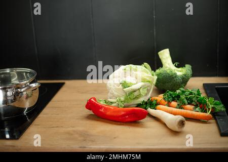 Table de cuisine avec pile de légumes frais mûrs. Savoureux poivron, brocoli, carottes, légumes verts, chou-fleur. Banque D'Images
