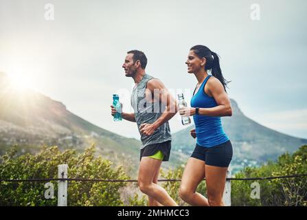 Courir peut être amusant avec votre être aimé. un jeune couple attrayant s'entraîner pour un marathon en plein air. Banque D'Images