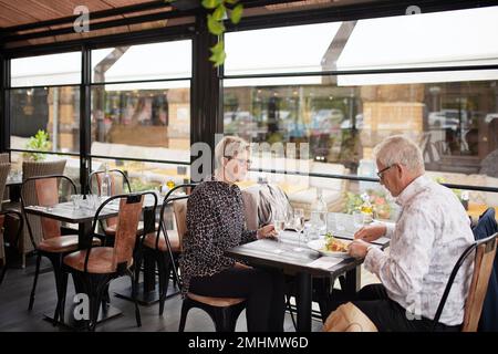 Un couple d'âge mûr dînant au restaurant Banque D'Images