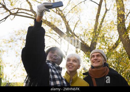 De jeunes amis souriants prennent le selfie Banque D'Images