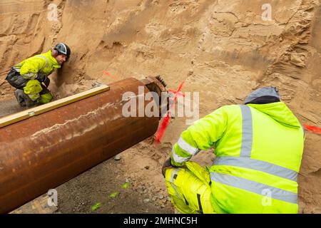 Hommes installant des tuyaux sur le chantier Banque D'Images