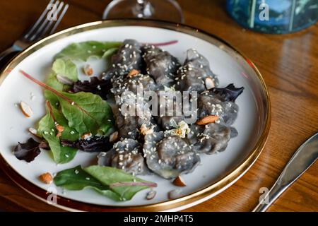 Un morceau de saumon grillé poivre citron et sel sur une assiette brune avec des feuilles de laitue. arrière-plan en bois. Photo de haute qualité Banque D'Images
