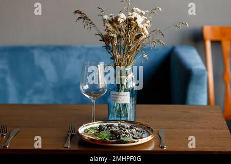 Un morceau de saumon grillé poivre citron et sel sur une assiette brune avec des feuilles de laitue. arrière-plan en bois. Photo de haute qualité Banque D'Images
