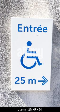 le texte français de l'entrée accessible aux personnes handicapées signifie l'affichage de l'affiche d'entrée avec le logo pour les personnes handicapées en fauteuil roulant et la flèche pointant vers le côté de l'accès au magasin à l'entrée murale p Banque D'Images