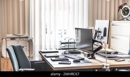 Bureau vide équipé d'ordinateurs, de tablettes, d'imprimantes et de meubles de bureau. Banque D'Images