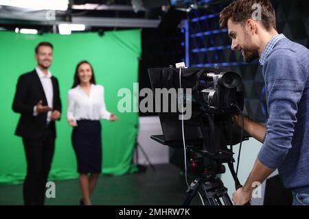 Présentateurs et caméraman travaillant en studio. Diffusion de nouvelles Banque D'Images